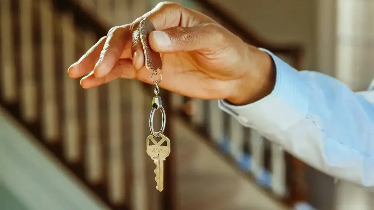 Main tenant, une main tenant une clé, symbole de la possibilité de louer son appartement.