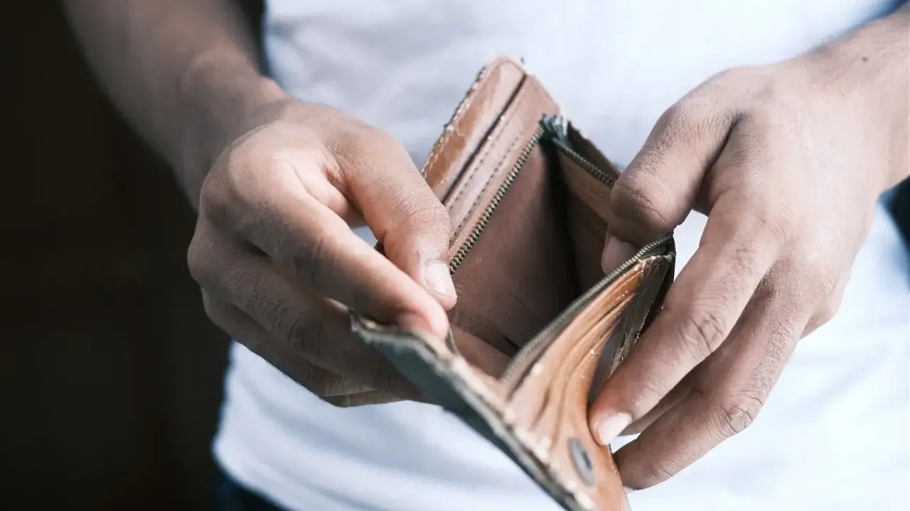 Mains vides tenant un portefeuille ouvert et vide. Une situation qui peut pousser à ne pas payer le loyer pour faire pression.