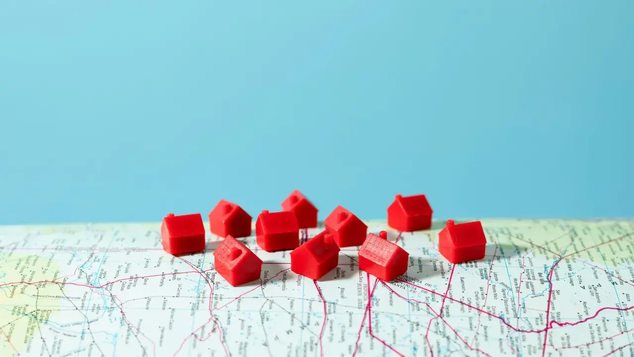 Petites maisons rouges sur une carte, symbolisant la crise du logement en France.
