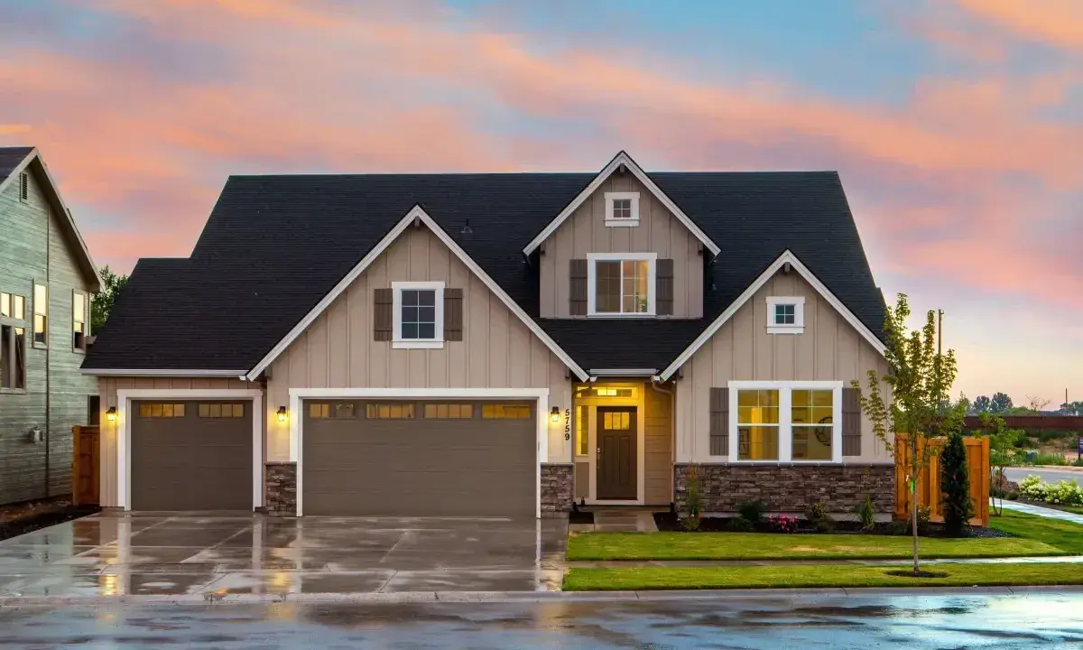 Belle maison avec garage double sous un ciel de crépuscule. Une image parfaite pour illustrer la condition pour acheter une maison.