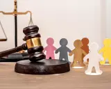 Marteau de juge, balance de la justice et figurines représentant des personnes. Un locataire à éviter peut entraîner des litiges.