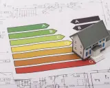 Maquette de maison ancienne sur des plans, avec un barème DPE. Le prix d'une maison ancienne dépend de sa performance énergétique.
