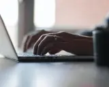 Mains tapant sur un ordinateur portable, recherchant comment déclarer une location meublée à l'année.