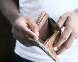 Mains vides tenant un portefeuille ouvert et vide. Une situation qui peut pousser à ne pas payer le loyer pour faire pression.
