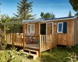 Mobil-home en bois avec terrasse, table et chaises. Découvrez quelle condition pour mettre un mobil-home sur son terrain.