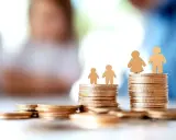 Des piles de pièces d'or symbolisent la question : quel salaire pour emprunter 200 000 euros ? Des silhouettes familiales sont posées sur les monticules.