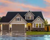 Belle maison avec garage double sous un ciel de crépuscule. Une image parfaite pour illustrer la condition pour acheter une maison.
