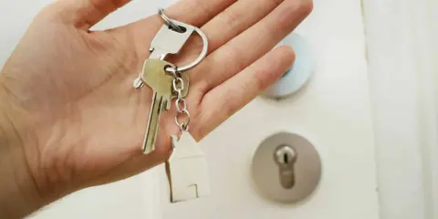 Main tenant, quel apport pour emprunter 300 000 euros ? Clés d'une maison avec un porte-clés en forme de maison.