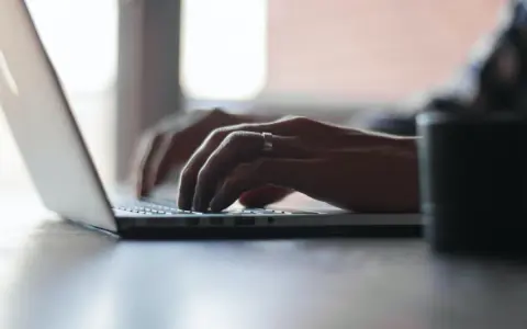 Mains tapant sur un ordinateur portable, recherchant comment déclarer une location meublée à l'année.