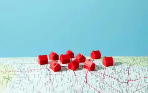 Petites maisons rouges sur une carte, symbolisant la crise du logement en France.