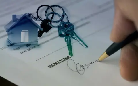 Clés d'une maison sur un contrat, symbolisant un prêt consommation pour achat immobilier. Signature apposée.