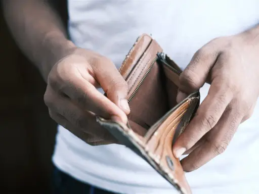 Mains vides tenant un portefeuille ouvert et vide. Une situation qui peut pousser à ne pas payer le loyer pour faire pression.