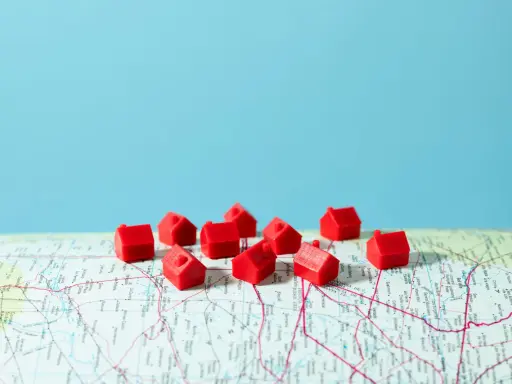 Petites maisons rouges sur une carte, symbolisant la crise du logement en France.