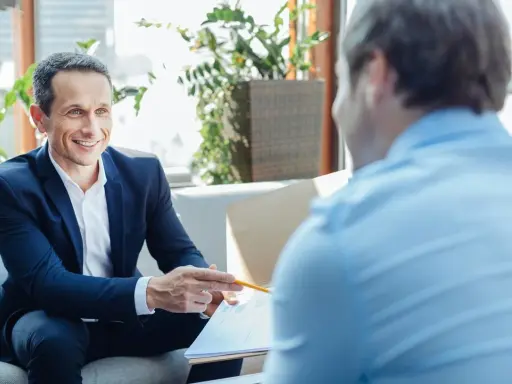 Un homme souriant en costume explique un document, discutant du délai de l'offre de prêt.