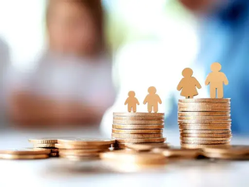 Des piles de pièces d'or symbolisent la question : quel salaire pour emprunter 200 000 euros ? Des silhouettes familiales sont posées sur les monticules.