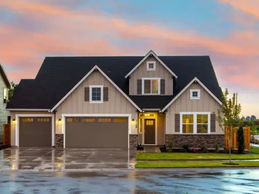 Belle maison avec garage double sous un ciel de crépuscule. Une image parfaite pour illustrer la condition pour acheter une maison.