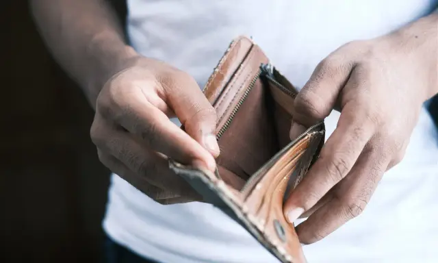Mains vides tenant un portefeuille ouvert et vide. Une situation qui peut pousser à ne pas payer le loyer pour faire pression.