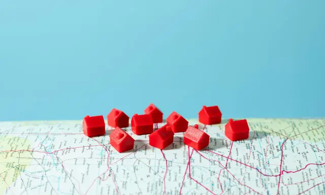 Petites maisons rouges sur une carte, symbolisant la crise du logement en France.