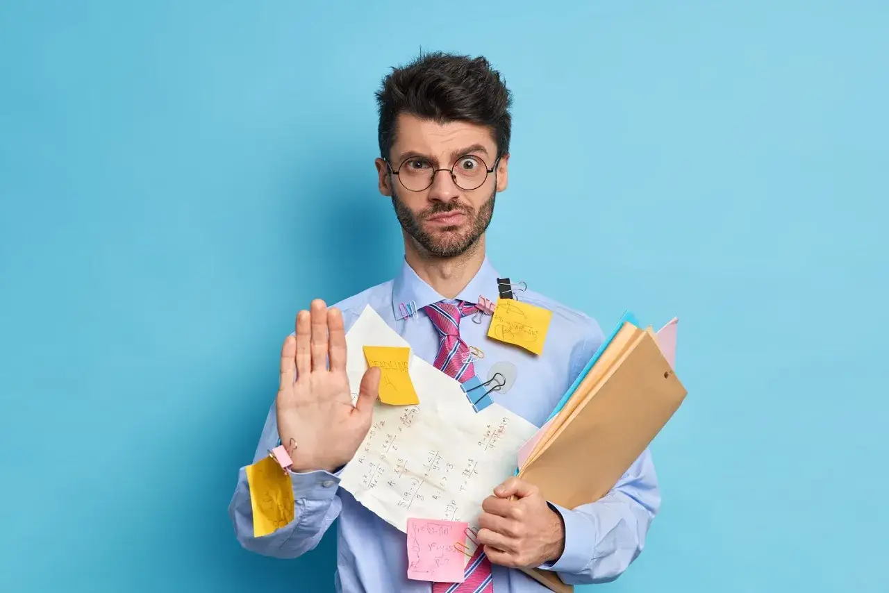 Homme d&eacute;pass&eacute; par les t&acirc;ches, avec des notes coll&eacute;es partout. Il tient des dossiers, comme s'il cherchait &agrave; finaliser un pap contrat de location meubl&eacute;.