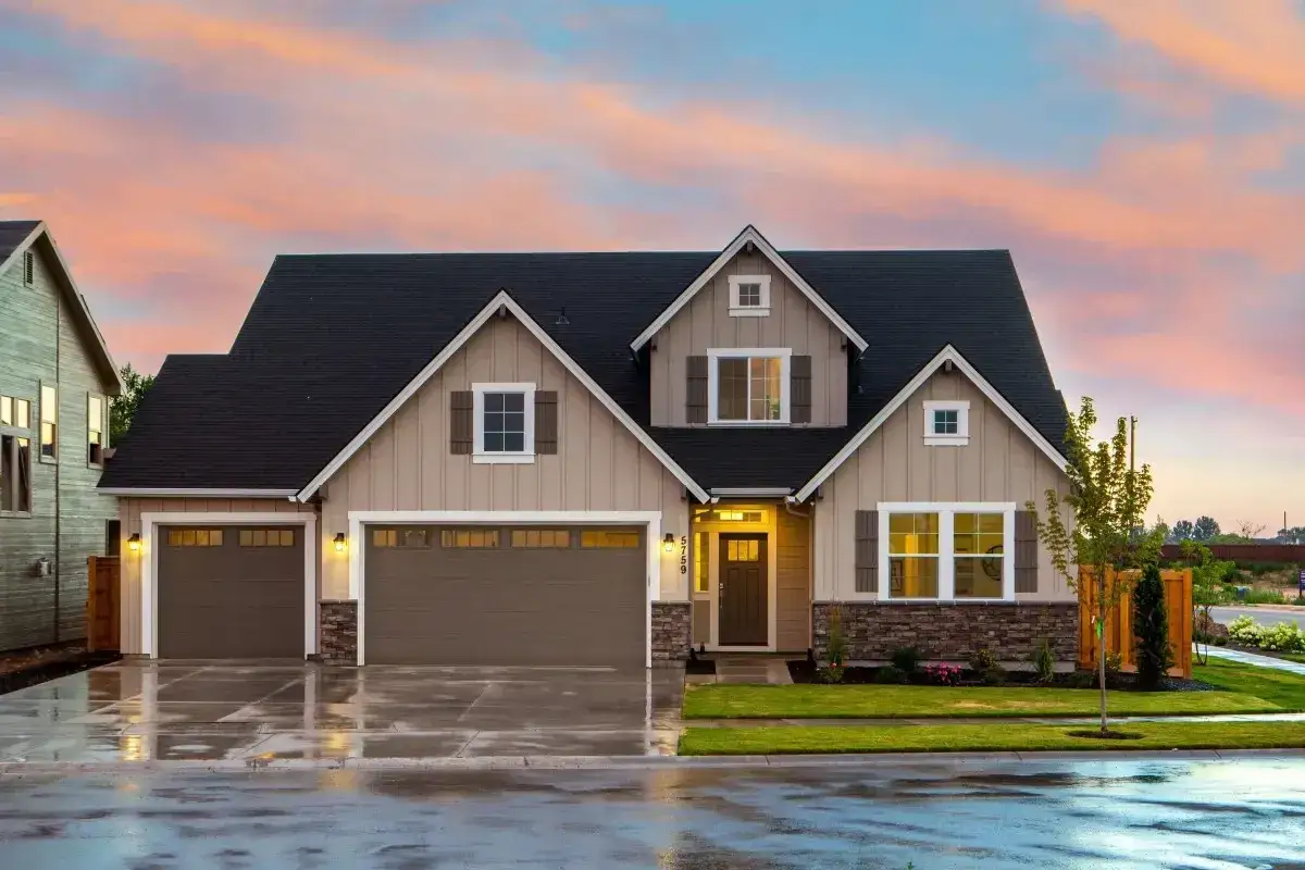 Belle maison avec trois garages, sous un ciel de cr&eacute;puscule. Une image parfaite pour illustrer la condition pour acheter une maison.