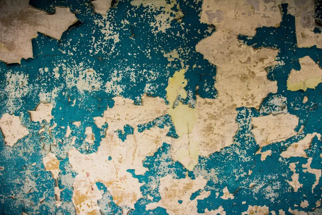 Peinture &eacute;caill&eacute;e r&eacute;v&eacute;lant des couches anciennes. Un rappel visuel de l'importance du diagnostic plomb, une obligation pour la s&eacute;curit&eacute;.