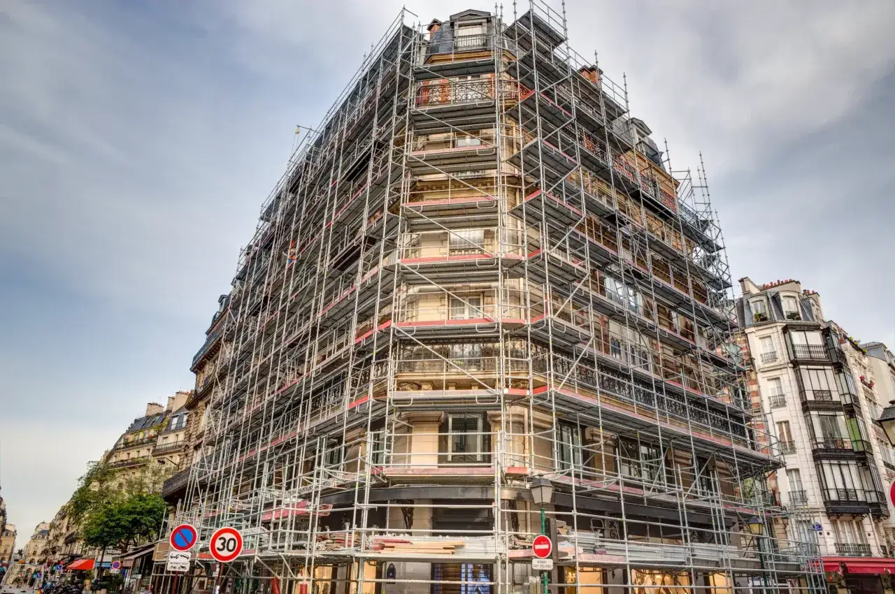 Immeuble parisien enti&egrave;rement recouvert d'&eacute;chafaudages, pr&ecirc;t pour une vente et une r&eacute;novation.