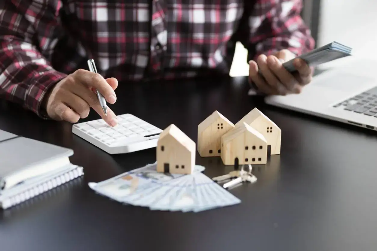 Calculatrice, petites maisons en bois, cl&eacute;s et argent pour la r&eacute;cup&eacute;ration TVA LMNP.