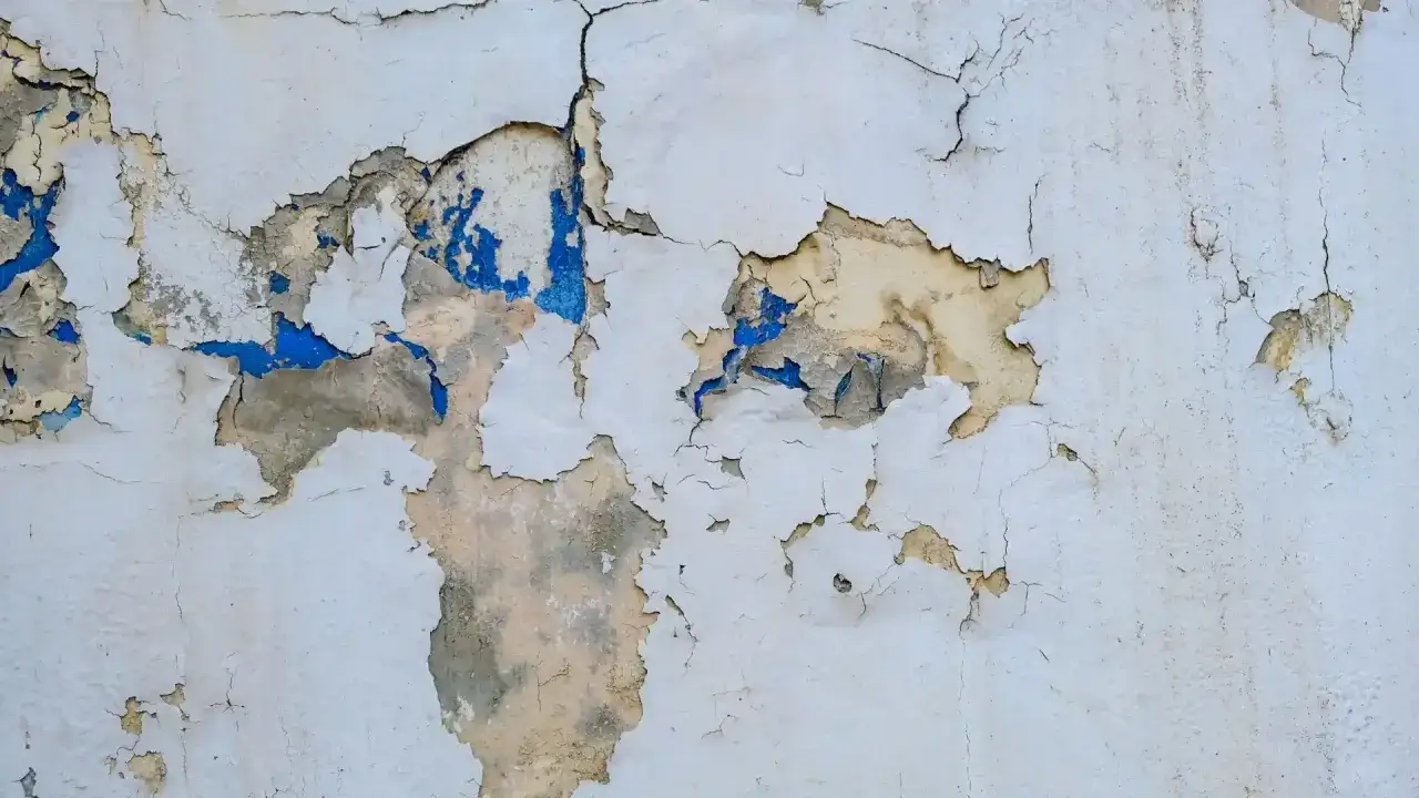 Mur d&eacute;cr&eacute;pi r&eacute;v&eacute;lant des couches de peinture &eacute;caill&eacute;e, bleu et ocre. Un visuel qui rappelle l'importance du prix diagnostic plomb pour la s&eacute;curit&eacute;.