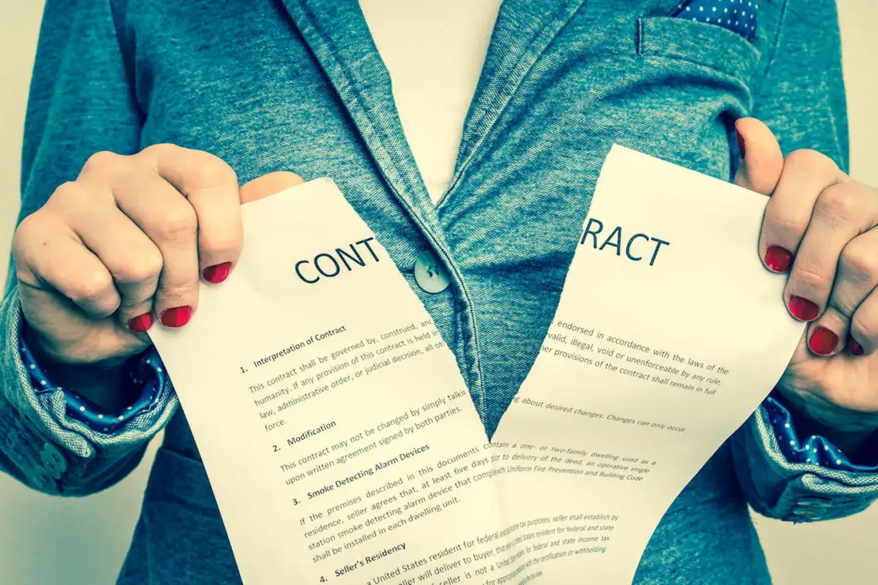 Main tenant d&eacute;chire un contrat. Elle regrette d'avoir sign&eacute; ce compromis de vente.
